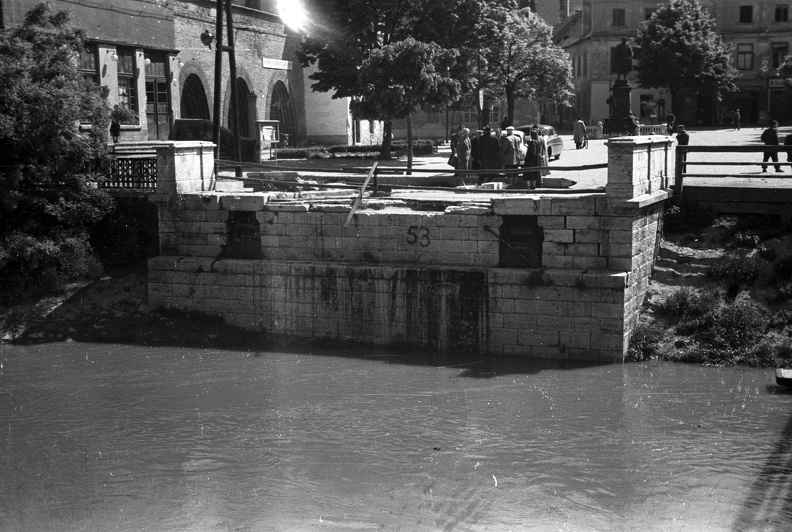 az 1945 márciusában felrobbantott Rába Kettős híd hídfője az ideiglenes fahídról nézve. Szemben a Bécsi kapu tér.