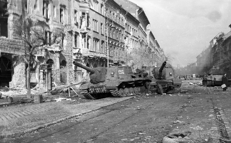 József körút a Corvin (Kisfaludy) köztől nézve. Harcképtelenné tett ISU-152-es szovjet rohamlövegek, a háttérben egy T-34/85 harckocsi.