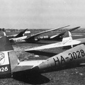 Előtérben egy Rubik R-08c Pilis, balra két Jancsó-Szokolay M-22, jobbra hátrébb egy sötét színű Göppingen Gö-4 vitorlázó repülőgép.