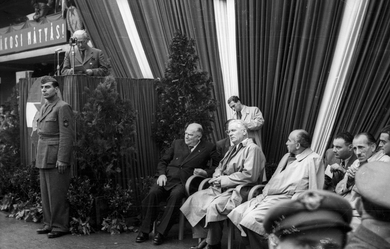 Erzsébet (Sztálin) tér, a MÁVAUT autóbusz-pályaudvar átadási ünnepsége 1949. szeptember 11-én. A mikrofonnál Nyiri István építész, az épület tervezője. Az emelvény mellett ül sötét öltönyben Bebrits Lajos közlekedésügyi miniszter.