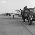 repülőtér, elől MiG-15UTI, mögötte MiG-15bisz vadászrepülőgépet vontatnak.